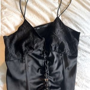 Silk black tank with criss cross details.